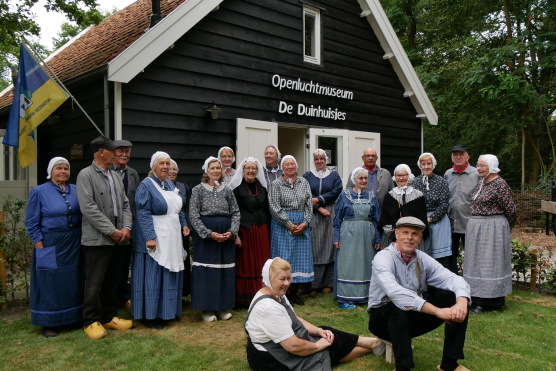 De groep 'Levende Geschiedenis' in streekdracht voor Openluchtmuseum Duinhuisjes